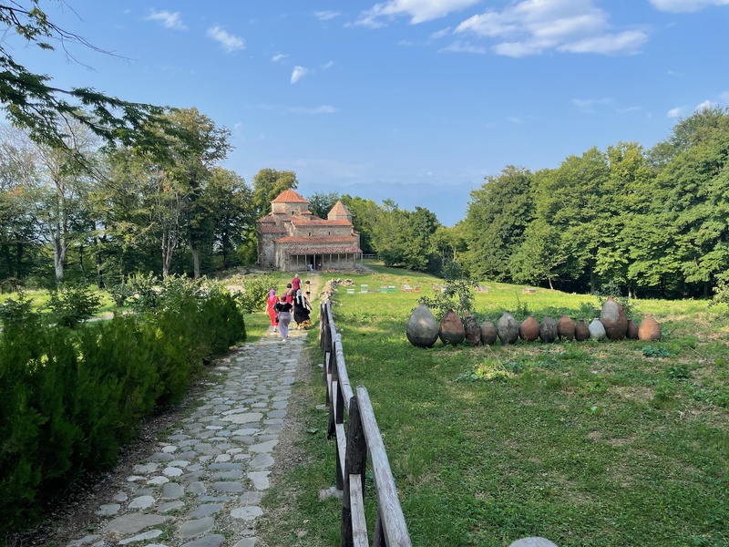 Ikalto Monastery — cobblestone path with qvevri