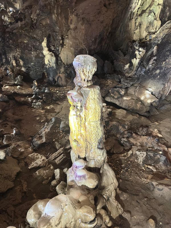 Close-up of a single golden-yellow stalagmite pillar